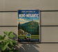 A vintage-style metal sign for the PARC NATIONAL DU MONT-MEGANTIC park in Quebec, Canada, featuring a scenic mountain landscape with pine trees and a small building on top.