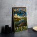 A vintage metal sign for the park, featuring an illustration of a horse, alligator, and bird in a grassy field with a body of water.