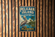 A vintage-style metal sign for Pelican Island National Wildlife Refuge in Florida, featuring a pelican and palm trees.