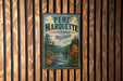 A vintage metal sign for the state forest in Michigan, featuring a scenic landscape with a river and pine trees.