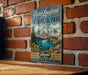 A vintage-style sign for Peter Loughheed Provincial Park in Alberta, Canada, featuring a scenic mountain landscape with a lake and pine trees.