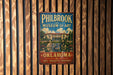 A vintage metal sign for the Philbrook Museum of Art in Oklahoma, featuring an illustration of a building with a fountain in the foreground.