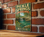 A vintage metal sign for Pickle Springs, a natural area in Missouri, is displayed on a brick wall.