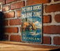 A vintage-style metal sign for Pictured Rocks National Lakeshore Marine Zone, featuring a scenic image of a boat on the water and a rocky shoreline.