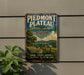 A vintage-style sign for Piedmont Plateau, Virginia, featuring a scenic landscape with a farm, trees, and a winding road.