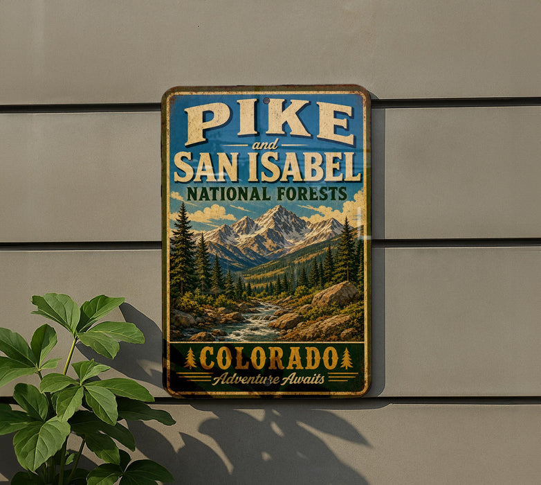 A vintage-style metal sign with a mountain landscape and a river, mounted on a wall.