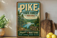 A vintage-style sign for Pike State Forest, Indiana, featuring a scenic image of the forest and a river.