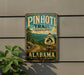 A vintage-style metal sign advertising the Pinhoti Trail in Alabama, featuring a scenic mountain landscape and the trail's name.