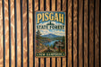 A vintage metal sign for Pisgah State Forest in New Hampshire, featuring a scenic landscape with a river, mountains, and pine trees.