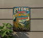 A vintage-style metal sign with the text "PITONS CIRQUES ET REMPARS DE LA REUNION" and "ILE DE LA REUNION FRANCE" is displayed on a wall, with a plant visible to the left.