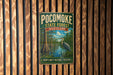 A vintage metal sign for the Pocomoke State Forest in Maryland, featuring an illustration of a bird standing in a pond surrounded by trees.