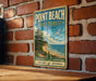 A vintage-style metal sign for Point Beach State Forest in Wisconsin, featuring a scenic landscape with a beach, pine trees, and a seagull in flight.