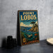 A vintage metal sign for Point Lobos State Marine Reserve, featuring an illustration of a coastal landscape with a seal and a lighthouse.
