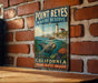 A vintage-style metal sign for Point Reyes Marine Reserve in California, featuring a seal swimming in the ocean and a lighthouse on a cliff.