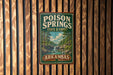 A vintage-style metal sign for the state forest of Arkansas, featuring a scenic illustration of a waterfall and forest.