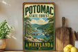 A vintage-style sign for Potomac State Forest in Maryland, featuring a scenic landscape with a river, mountains, and pine trees.