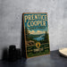 A vintage-style metal sign for Prentice Cooper State Forest, featuring a scenic landscape with pine trees, a river, and mountains.