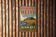 A vintage-style metal sign for Puukohola Heiau, the National Historic Site in Hawaii, is displayed on a wooden wall.