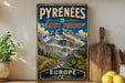 A vintage-style metal sign with a mountain landscape and a goat, advertising the Pyrenees region in Europe.