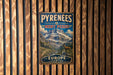 A vintage-style metal sign with the text "PYREENÉES MONT PERDU EUROPE" is displayed on a wooden wall.