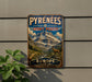 A vintage-style metal sign with the text "PYRENEES MÈT PERDU EUROPE" and an illustration of a mountain landscape with a goat.