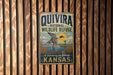 A vintage metal sign for the Quivira National Wildlife Refuge in Kansas, featuring a duck in flight and a serene landscape.