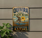 A vintage-style metal sign for the Quivira National Wildlife Refuge in Kansas, featuring a bird in flight and a serene landscape.