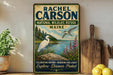 a vintage-style metal sign with a nature-themed illustration, including a bird, a lake, and a forest. The sign is displayed on a shelf next to a wooden cutting board and a potted plant.