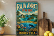 A vintage-style metal sign for Raja Ampat Park in Indonesia, featuring a tropical island landscape with palm trees, colorful fish, and a blue sky with clouds.