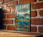 A vintage-style metal sign for Raja Ampat Park in Indonesia, featuring a tropical island landscape with a coral reef and marine life.