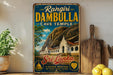A vintage-style metal sign advertising the "Rangiri Dambulla Cave Temple" in Sri Lanka, featuring a scenic image of the temple and a description of its cultural heritage.