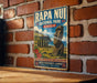A vintage metal sign for Rapa Nui National Park in Chile, featuring an illustration of the iconic Moai statues and the surrounding landscape.