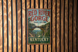 A vintage metal sign for the Red River Gorge Trail System in Kentucky, featuring a scenic illustration of the trail and the state's name.