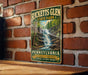 A vintage-style metal sign for Ricketts Glen State Park in Pennsylvania, featuring a waterfall and forest scenery.