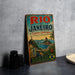 A vintage-style metal sign for Rio de Janeiro, Brazil, featuring a colorful illustration of the city's landscape and landmarks.
