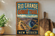 A vintage-style poster of the Rio Grande Gorge Trail in New Mexico, featuring a scenic mountain landscape with a winding trail.