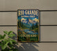 A vintage-style metal sign for the Rio Grande National Forest in Colorado, featuring a scenic mountain landscape with pine trees, a river, and a waterfall.