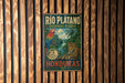 A vintage-style metal sign for the Rio Plateano Biosphere Reserve in Honduras, featuring a colorful illustration of a parrot and a jaguar.