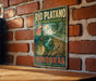 A vintage-style metal sign with a tropical landscape and a parrot, mounted on a brick wall.