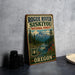 A vintage-style metal sign for Rogue River Siskiyou National Forest in Oregon, featuring a scenic mountain landscape and a river.