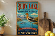 A vintage-style sign for Ruby Lake National Wildlife Refuge in Nevada, featuring an illustration of a bird standing on a lake with mountains in the background.