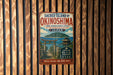 a vintage-style sign for the Sacred Island of Okinawa, Japan, with a wooden background and a Japanese-style illustration of a temple and a mountain.