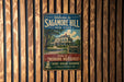 A vintage-style metal sign welcoming visitors to Sagamore Hill, New York, with a depiction of a house and a sign that says "Home of Theodore Roosevelt".