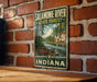 A vintage metal sign for the Salamonie River State Forest in Indiana, featuring a scenic image of a canoe on a river surrounded by trees.