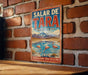 A vintage metal sign with the text "SALAR DE TARA CHILE" and a scenic illustration of a mountain range, water, and flamingos.
