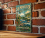A vintage metal sign for the Salmon River State Forest in Connecticut, featuring a scenic illustration of a river surrounded by mountains and forests.