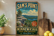 A vintage-style sign for Sam's Point Area in Minnewaska, New York, featuring a scenic mountain landscape with a lake in the background.