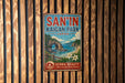 A vintage metal sign for San'In Kaigan Park, Japan, featuring a scenic landscape with a rocky arch, ocean, and flowers.