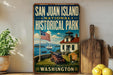 A vintage-style sign for San Juan Island National Historical Park, featuring an American flag, a lighthouse, and a house, is displayed on a shelf next to a wooden cutting board and some lemons.