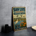 A vintage-style sign for San Luis National Wildlife Refuge in California, featuring an illustration of birds and wildlife in a natural setting.